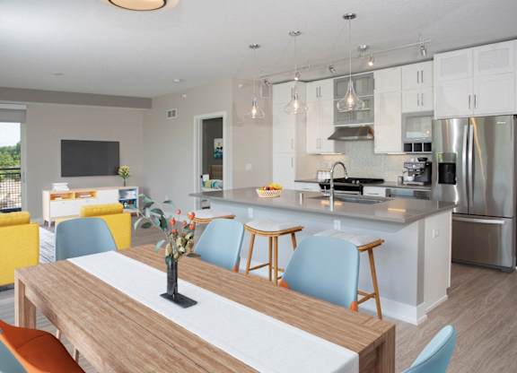 A modern kitchen with a wooden table and blue chairs.