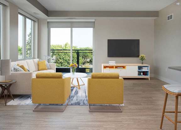 A living room with a white couch, yellow chairs, and a flat screen TV.
