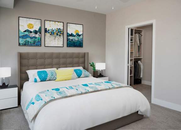 A bedroom with a large bed and two paintings on the wall.