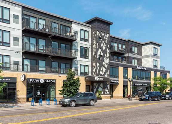 A street view of a building with a car parked in front.