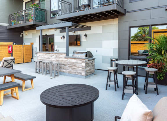 A patio area with a table, chairs, and a fireplace.