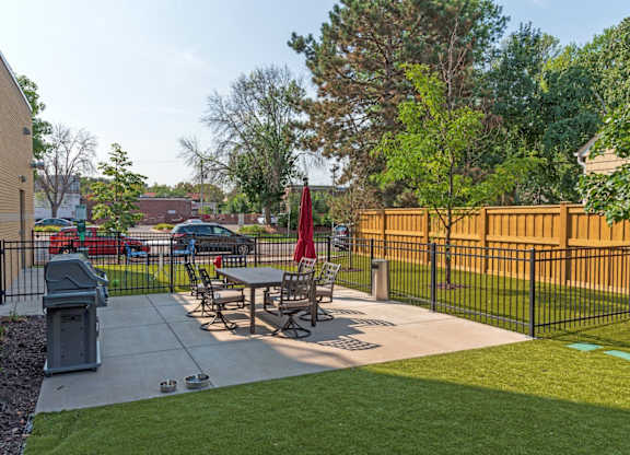 A black fence surrounds a picnic table in a park.