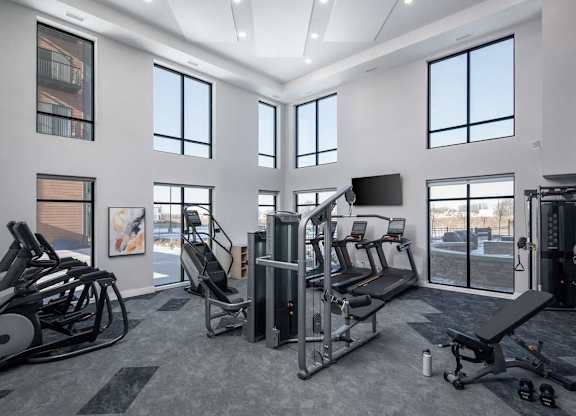 A gym with a variety of equipment including treadmills, weights, and exercise machines.at The Edison at Maple Grove, Maple Grove, MN 55311