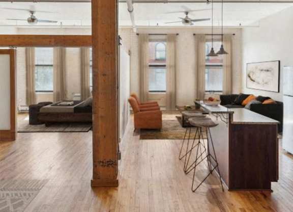 A living room with a brown floor and a white ceiling.at Lee Lofts, Minneapolis, MN
