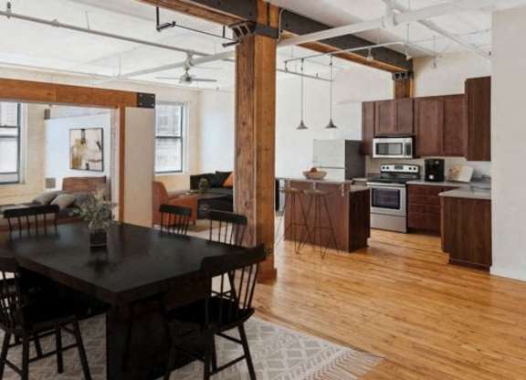A modern kitchen with wooden floors and a dining table with chairs.at Lee Lofts, Minnesota, 55401