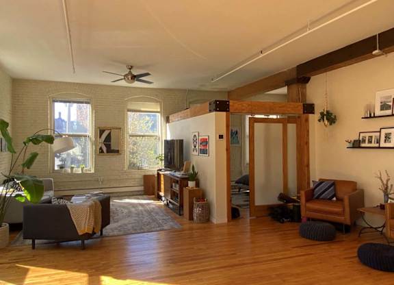 A living room with a wooden floor and a ceiling fan.at Lee Lofts, Minneapolis, MN 