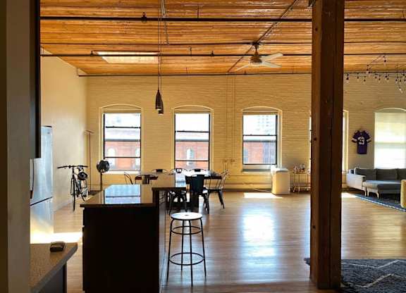 A kitchen with a bar stool and a table with chairs.at Lee Lofts, Minneapolis, MN 55401
