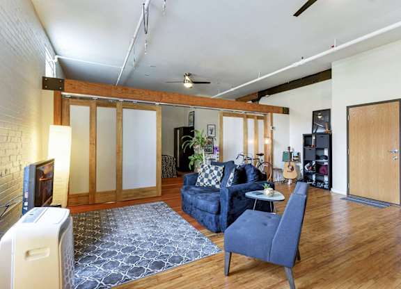 A living room with a blue couch and a grey rug.at Lee Lofts, Minneapolis