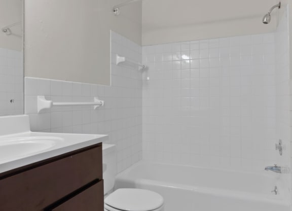 a bathroom with a toilet sink and bathtub in a 555 waverly unit