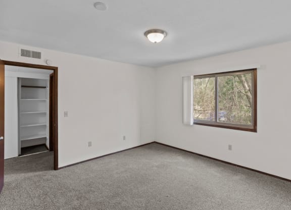 a bedroom with white walls and carpet
