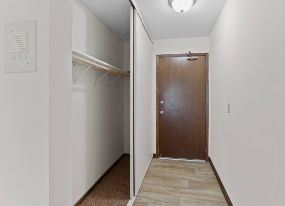 a hallway with a wooden door and a white wall