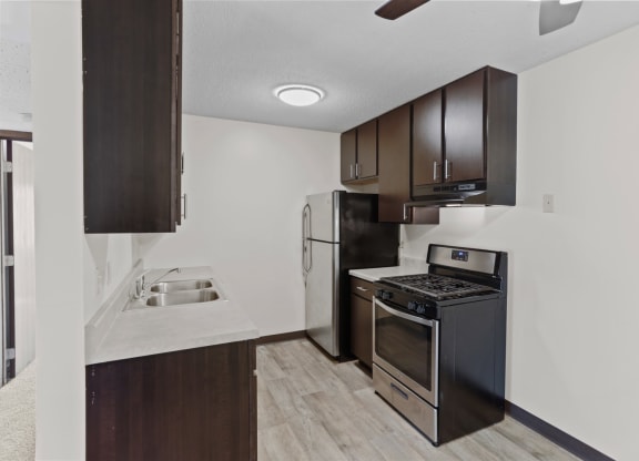 a kitchen with dark wood cabinetry and stainless steel appliances