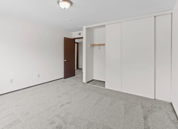a bedroom with white walls and a carpeted floor