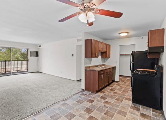 a kitchen and living room with a large window and a ceiling fan