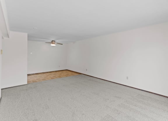 a bedroom with white walls and a ceiling fan