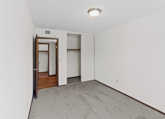a bedroom with white walls and carpet