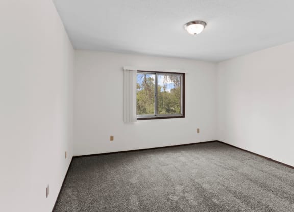 a bedroom with white walls and carpet