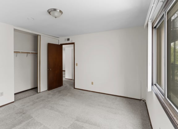 a bedroom with white walls and a large window