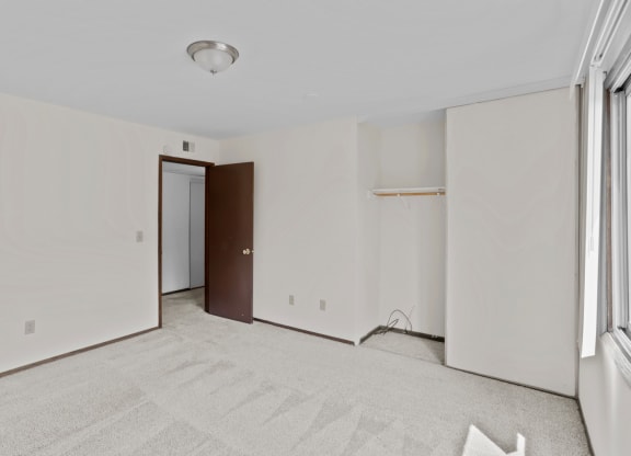 a bedroom with white walls and a white carpet
