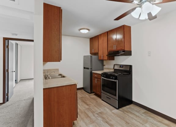 a kitchen with wooden cabinets and a ceiling fan