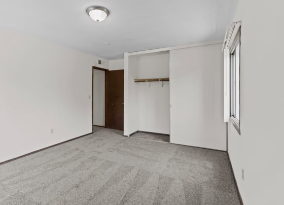 a bedroom with white walls and carpet