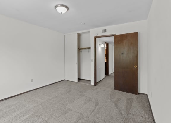 a bedroom with white walls and a carpeted floor