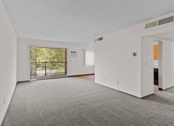 a bedroom with a large window and a door leading to a balcony