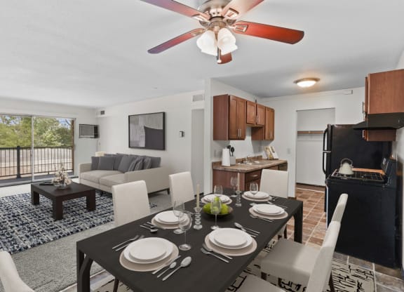 a living room and dining room with a table and chairs and a ceiling fan
