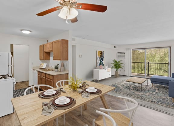a dining area with a wooden table and chairs and a kitchen in the background