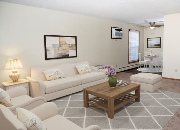 a living room with couches and a coffee table at Point of America Apartments, MN, 55443