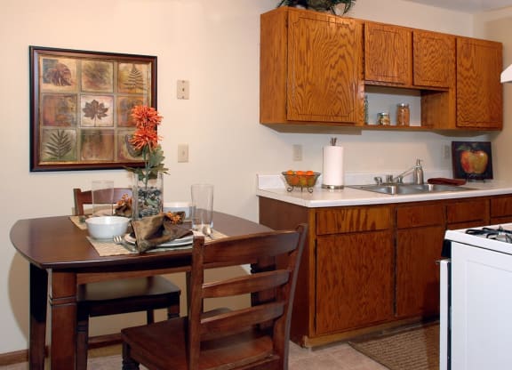Kitchen with brown cabinets at Point of America Apartments, MN, 55443