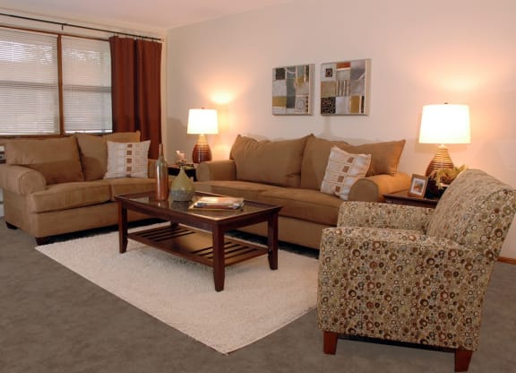 a living room with a couch chair and coffee table at Point of America Apartments, Brooklyn Park, MN