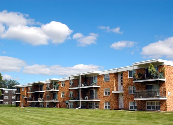 a grassy area in front of an apartment complex at Point of America Apartments,Minnesota, 55443