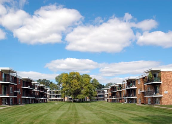 a grassy area between two rows of brick apartment buildings at Point of America Apartments,Minnesota
