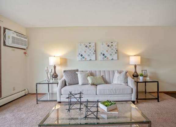 a living room with a white couch and a glass coffee table at Point of America Apartments,Minnesota, 55443