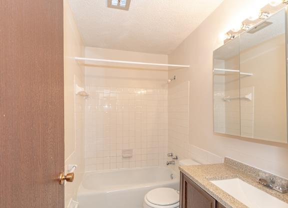 A bathroom with a toilet, sink, and bathtub.