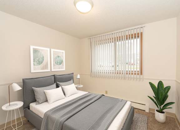 A bedroom with a bed, a plant, and two pictures on the wall.
