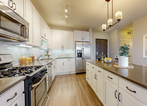 a large kitchen with white cabinets and stainless steel appliances