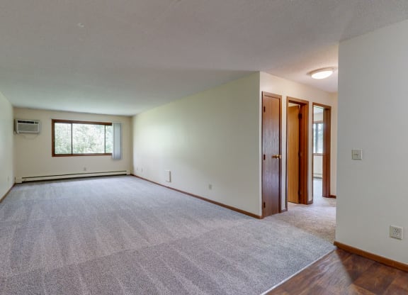 an empty living room with white walls and a carpeted floor