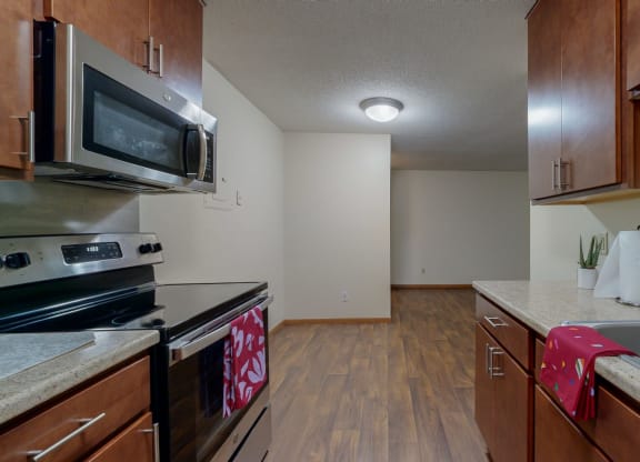 a kitchen with wood cabinets and stainless steel appliances