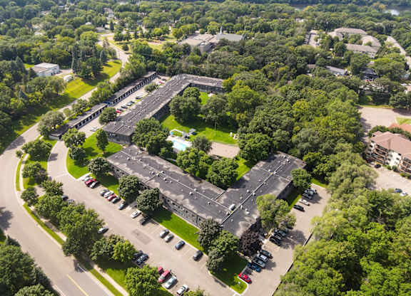 A large building surrounded by trees and a parking lot.