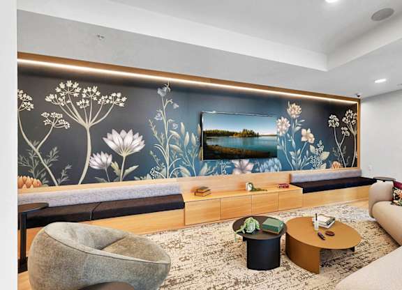 A living room with a large floral mural on the wall.