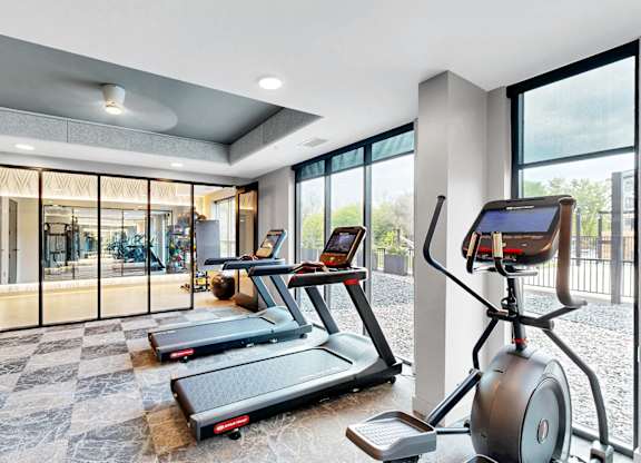 A modern home gym with treadmills and exercise bikes.