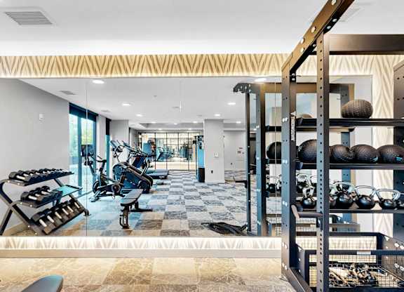 A gym with a variety of equipment including weights and machines.