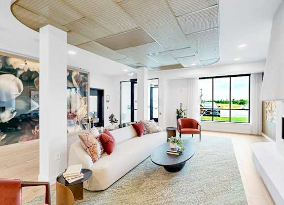 A modern living room with a white couch and a fireplace.