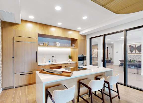 A modern kitchen with a wooden cabinet and white chairs.