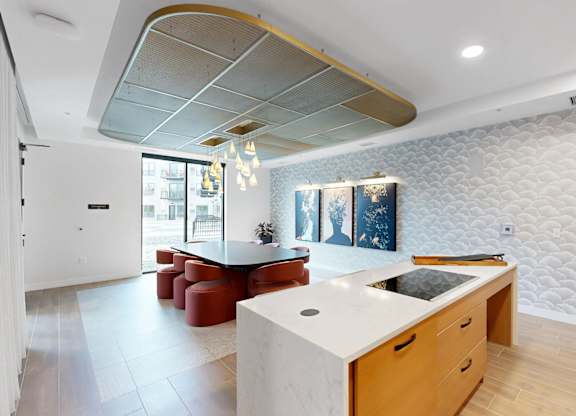 A kitchen with a white counter top and wooden cabinets.