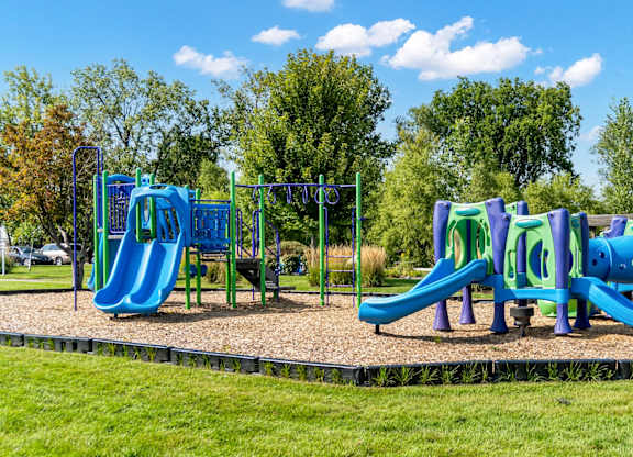 A playground with a blue slide and purple climbing frame.