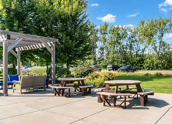 A picnic area with tables and chairs under a pergola.