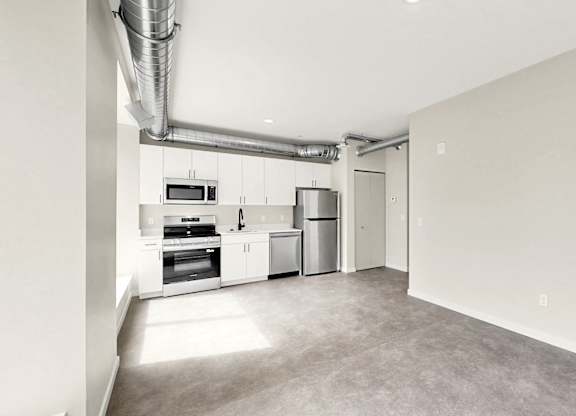 A kitchen area with a microwave, oven, and refrigerator.